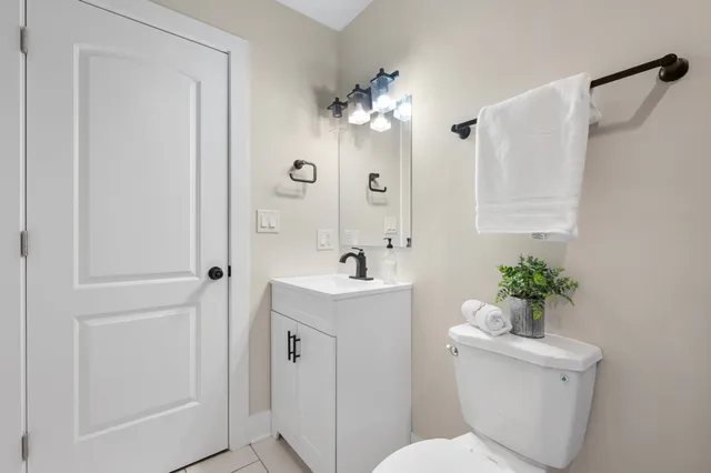 a bathroom with a sink mirror and a toilet