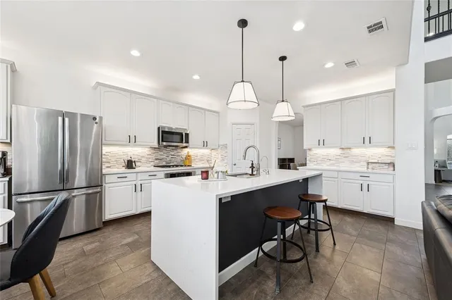 a kitchen with cabinets a sink stainless steel appliances and a window