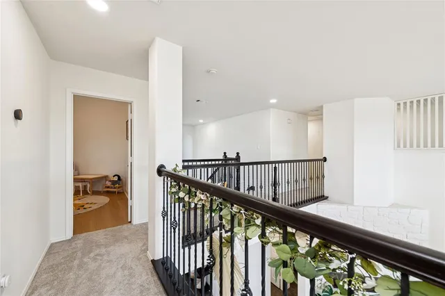 a view of a hallway with wooden floor and stairs