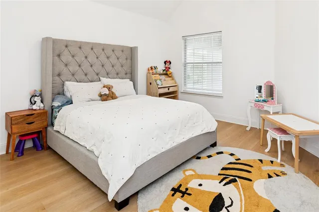 a bedroom with a bed and wooden floor