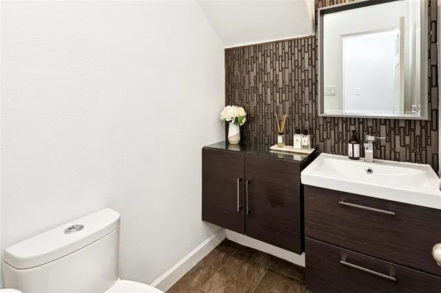 a bathroom with a sink vanity mirror and toilet