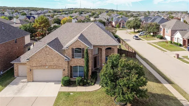 an aerial view of a house with a yard and mountain view