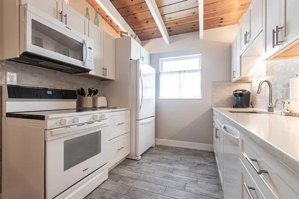 a kitchen with stainless steel appliances granite countertop a sink and a microwave