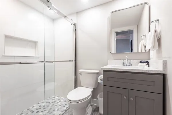 a bathroom with a granite countertop sink toilet and shower