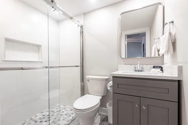 a bathroom with a granite countertop sink toilet and shower