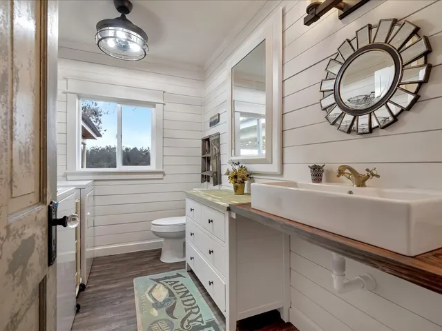 a bathroom with a toilet a sink and mirror