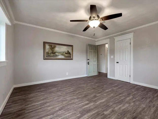 a view of an empty room with wooden floor