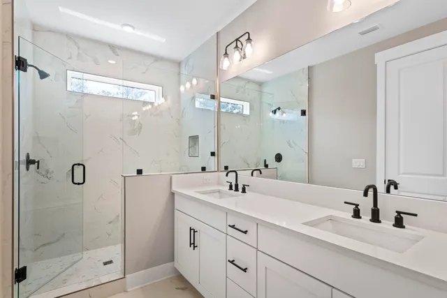 a bathroom with a double vanity sink mirror and shower