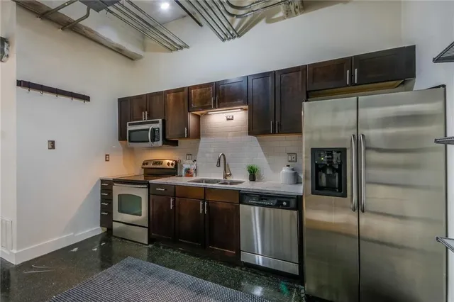 a kitchen with stainless steel appliances a refrigerator and a stove