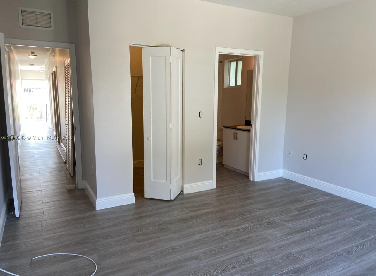 175 East 16th Street, Unit 175 Hialeah, FL 33010 - Photo 11 of 19 a view of a hallway with wooden floor and closet area
