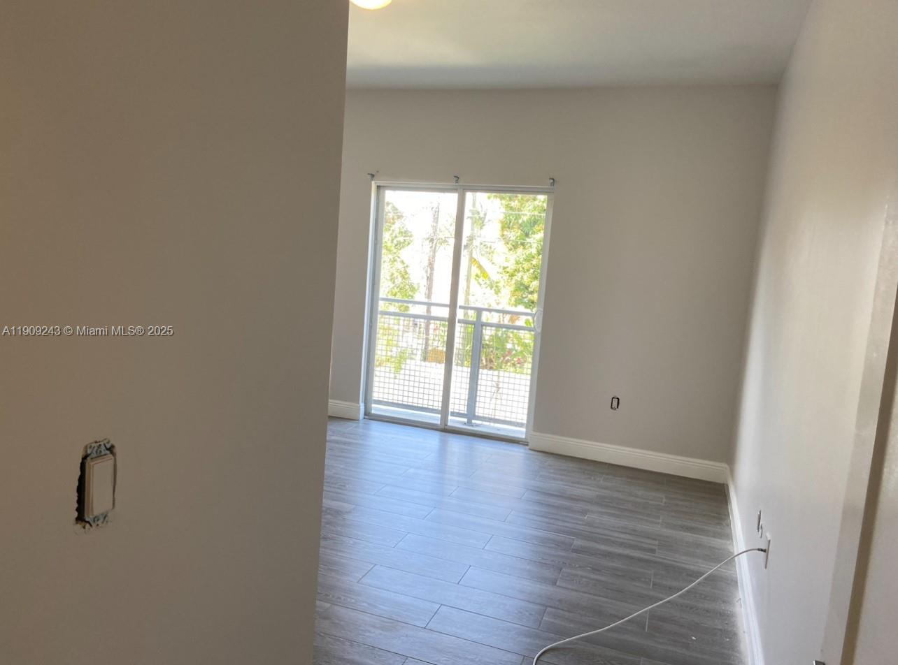 175 East 16th Street, Unit 175 Hialeah, FL 33010 - Photo 12 of 19 a view of an empty room with wooden floor and a window