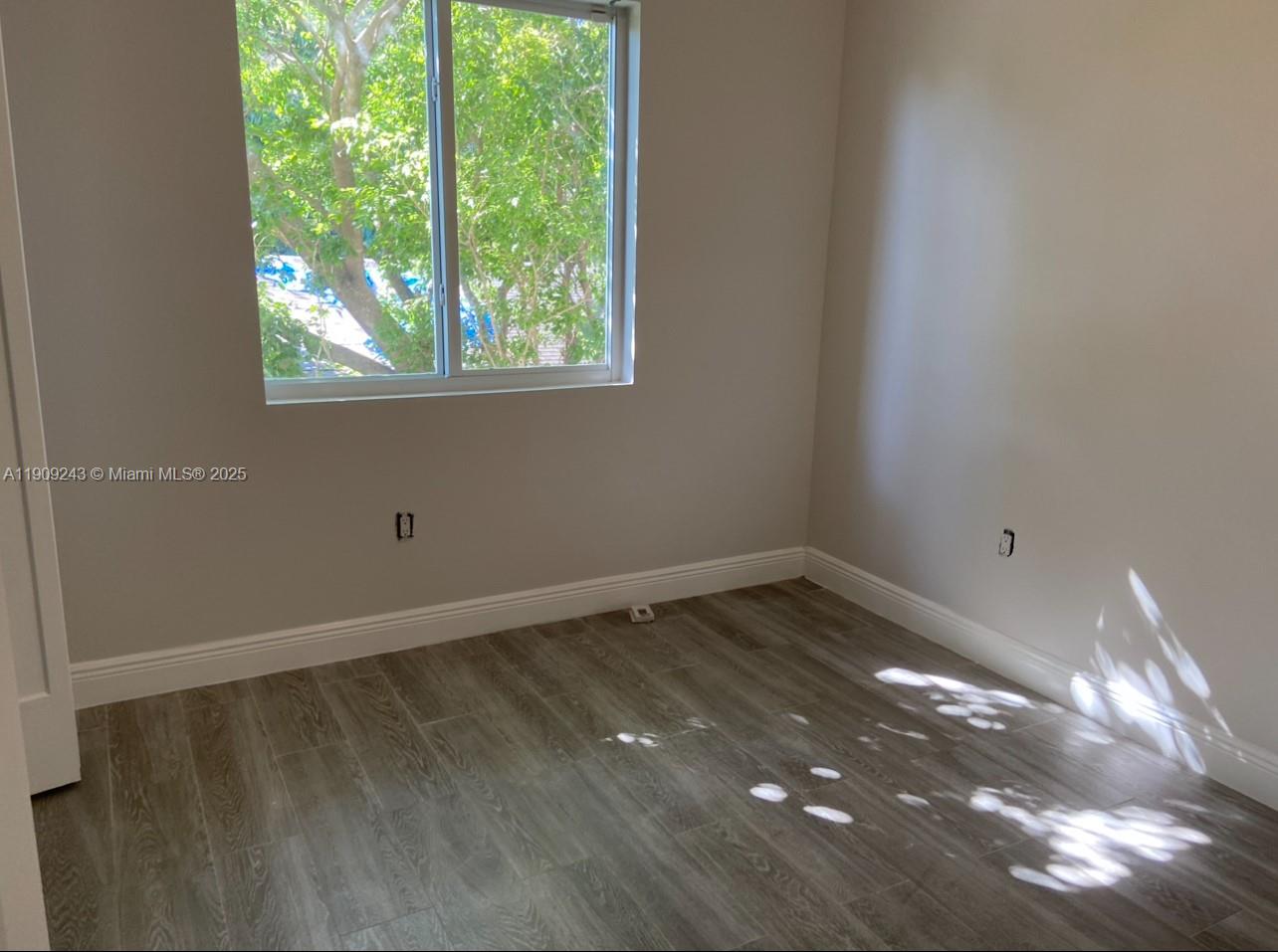 175 East 16th Street, Unit 175 Hialeah, FL 33010 - Photo 14 of 19 a view of an empty room with wooden floor and a window