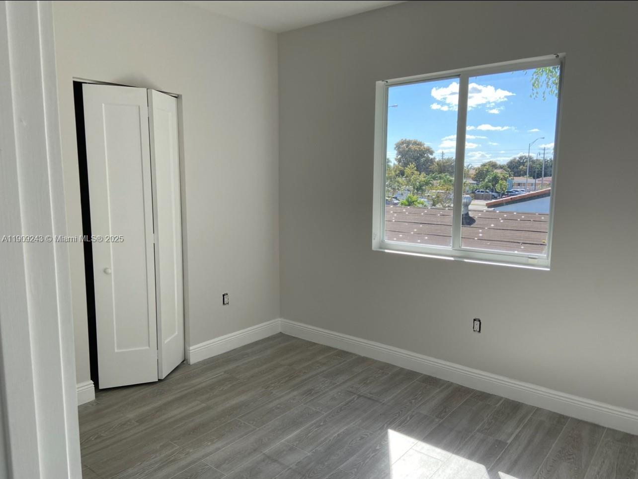 175 East 16th Street, Unit 175 Hialeah, FL 33010 - Photo 17 of 19 an empty room with wooden floor and windows