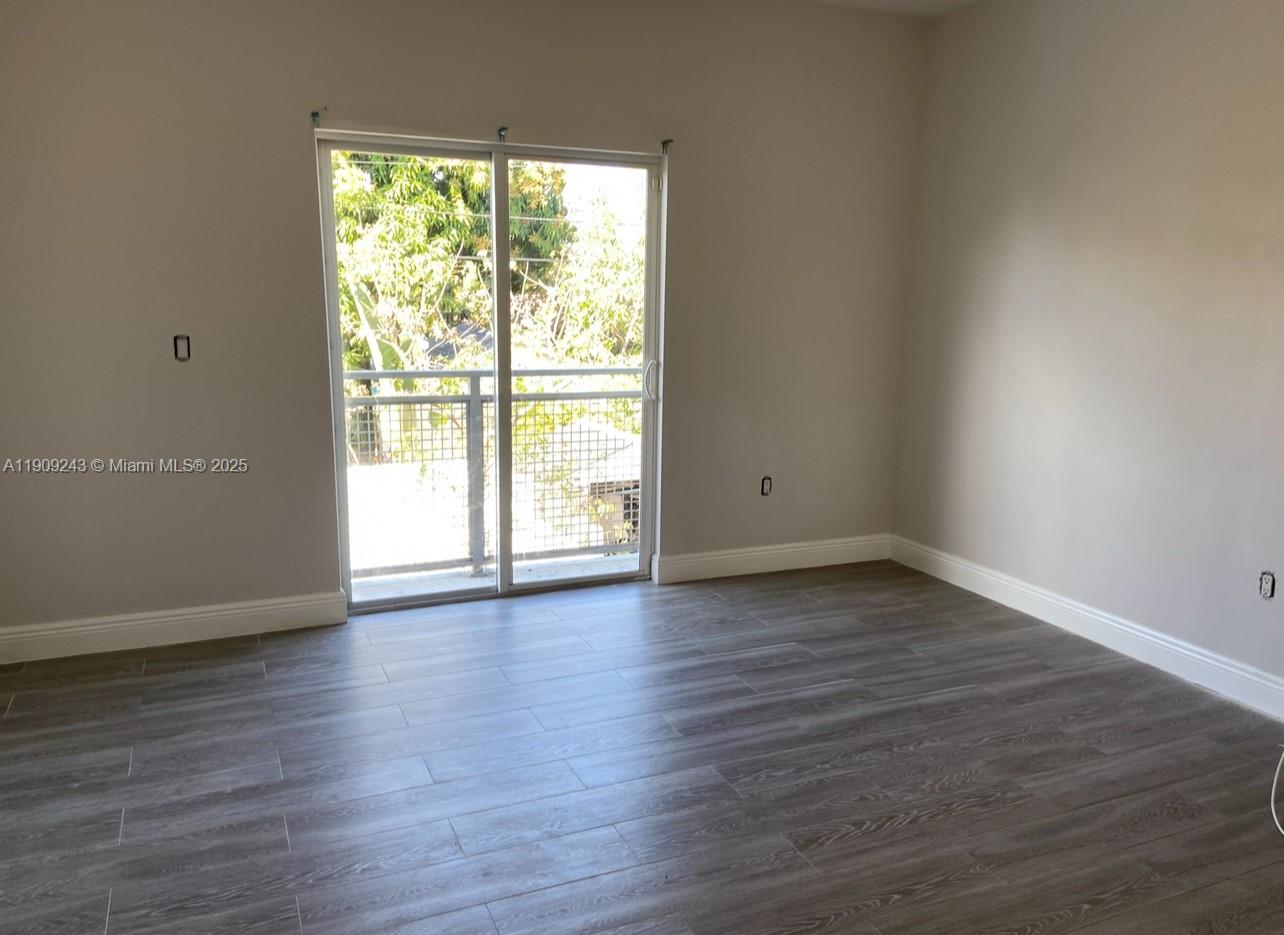 175 East 16th Street, Unit 175 Hialeah, FL 33010 - Photo 7 of 19 a view of an empty room with wooden floor and a window