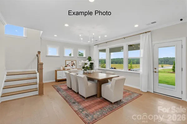 a large kitchen with kitchen island a large counter top space a sink stainless steel appliances and a chandelier