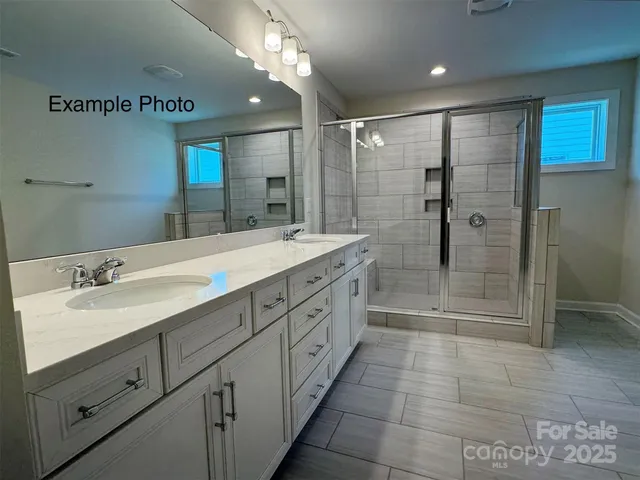 a spacious bathroom with a shower sink and mirror