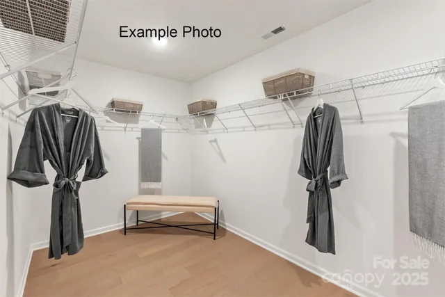 a view of walk in closet with clothes and shoes