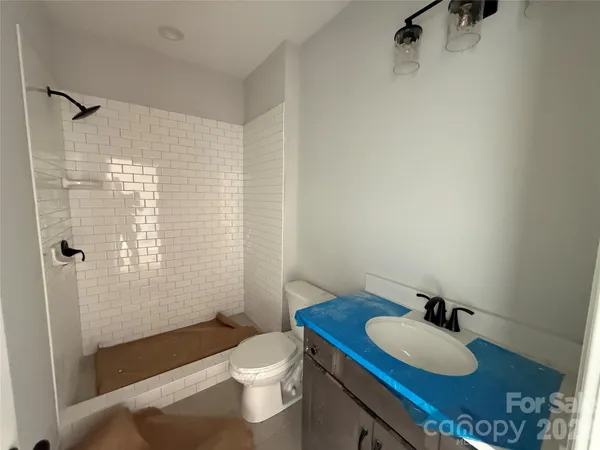 a bath tub sitting next to a white toilet and a shower curtain