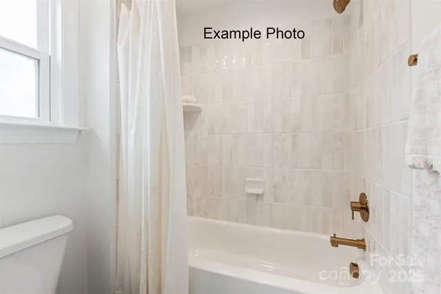a bath tub sitting next to a white toilet and a shower curtain