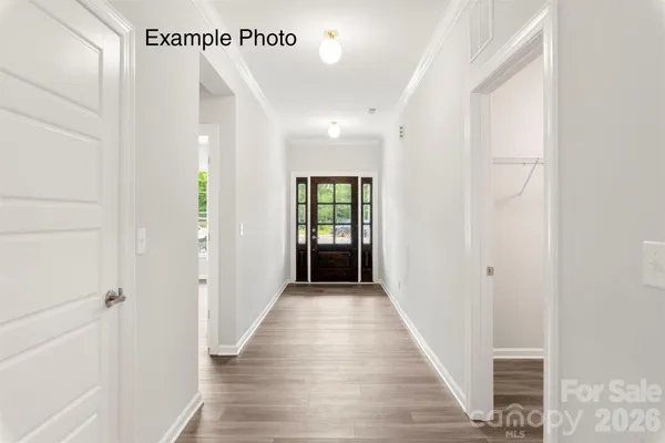 a view of a hallway with wooden floor and closet