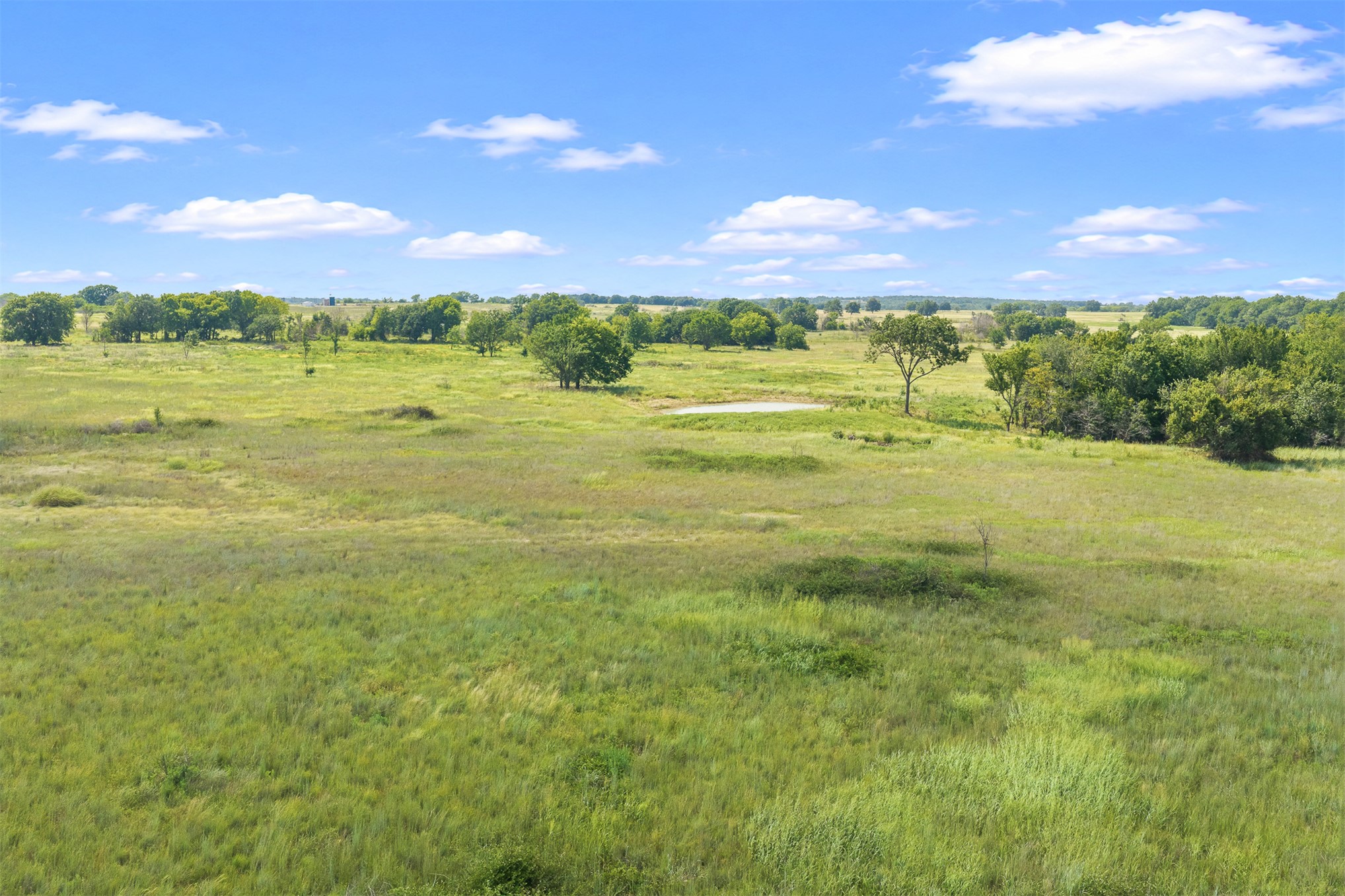 4 Keller Road Wilson, OK 73463 - Photo 18 of 32 Expansive open field featuring natural grasses, mature trees, and a visible pond