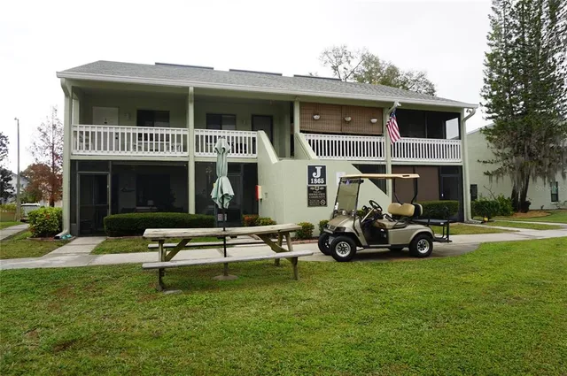 a view of a house with a yard and sitting area