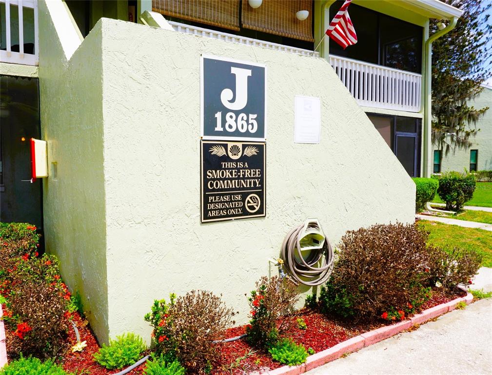 1865 Mazo Manor Road, Unit J5 Lutz, FL 33558 - Photo 1 of 23 a sign that is on the side of a building