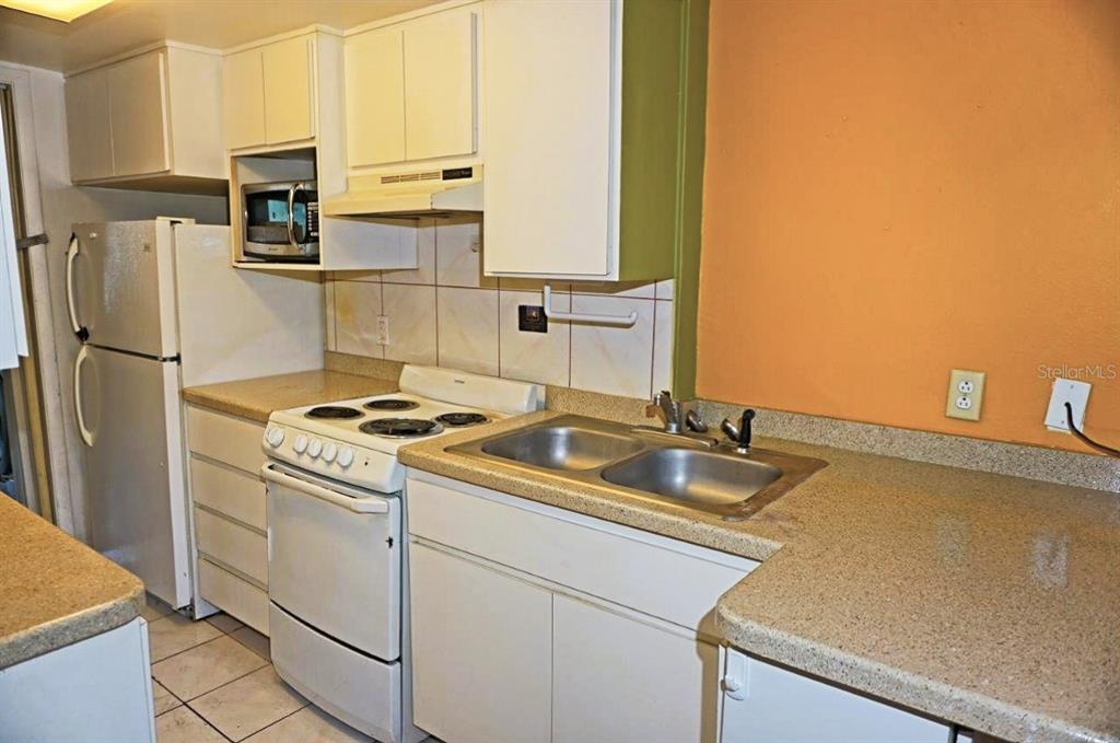 1865 Mazo Manor Road, Unit J5 Lutz, FL 33558 - Photo 3 of 23 a kitchen with stainless steel appliances granite countertop a sink stove and refrigerator