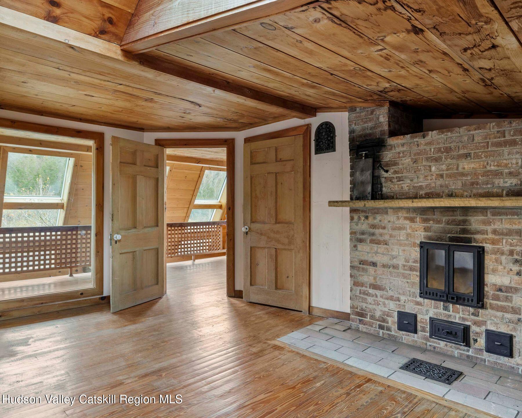 187 Beaver Hill Road Conesville, NY 12076 - Photo 47 of 79 a view of an empty room with wooden floor and a fireplace