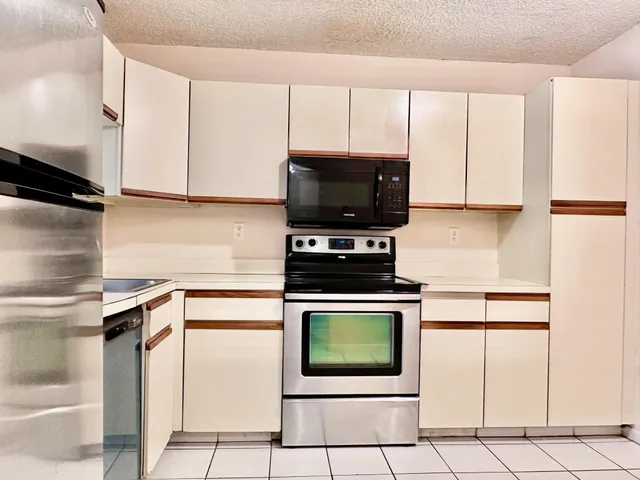a kitchen with stainless steel appliances granite countertop a stove top oven microwave and cabinets
