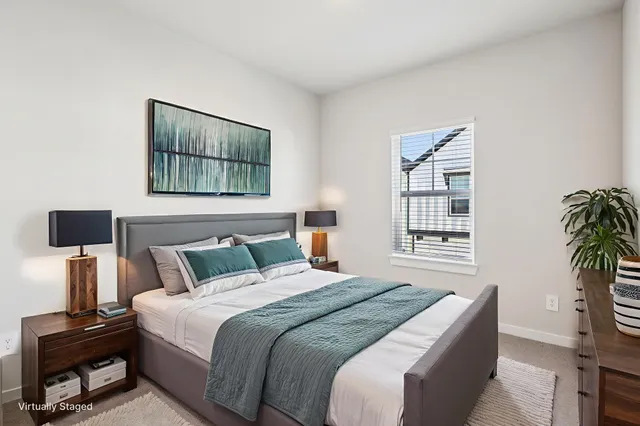 a bedroom with a bed a couch and potted plant next to a window