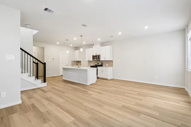 a view of kitchen with kitchen island microwave and stove top oven