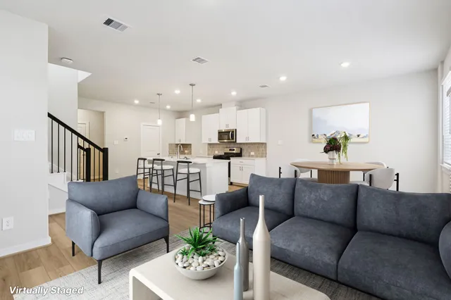 a living room with furniture kitchen and a potted plant