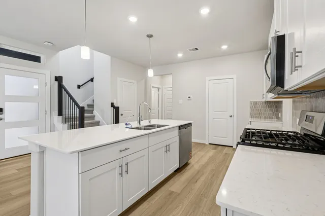 a kitchen with sink a stove and cabinets