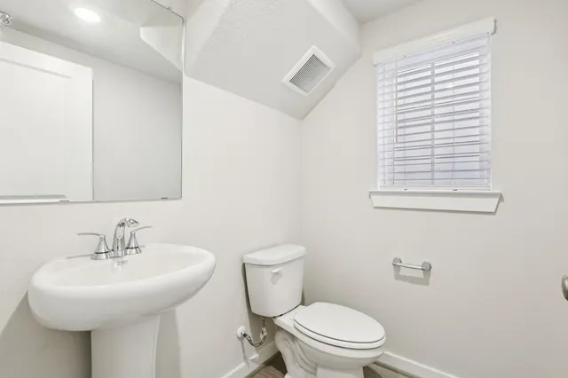 a bathroom with a sink a toilet and a mirror