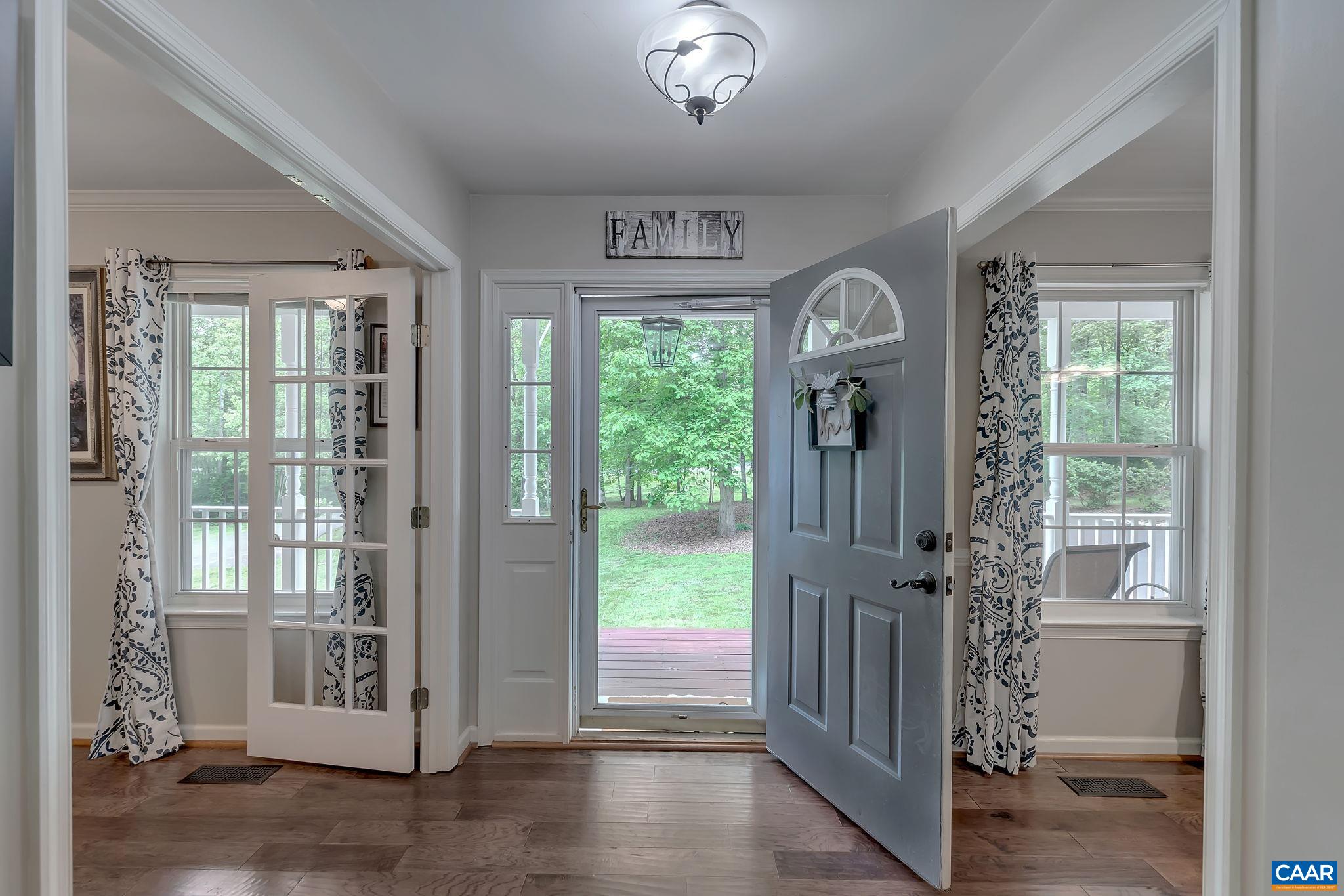 460 Northridge Road Ruckersville, VA 22968 - Photo 7 of 40 a view of a hallway to a livingroom with wooden floor and a window