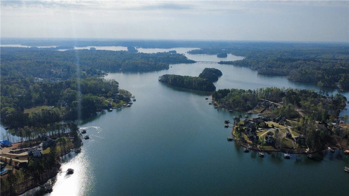 128 McAlister Road West Union, SC 29696 - Photo 4 of 40 A sprawling lakefront panorama showcasing serene waters, lush green shorelines, and homes nestled among mature trees.