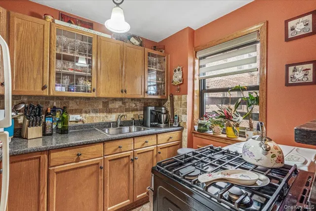 a kitchen with stainless steel appliances granite countertop a stove a sink dishwasher and cabinets with wooden floor