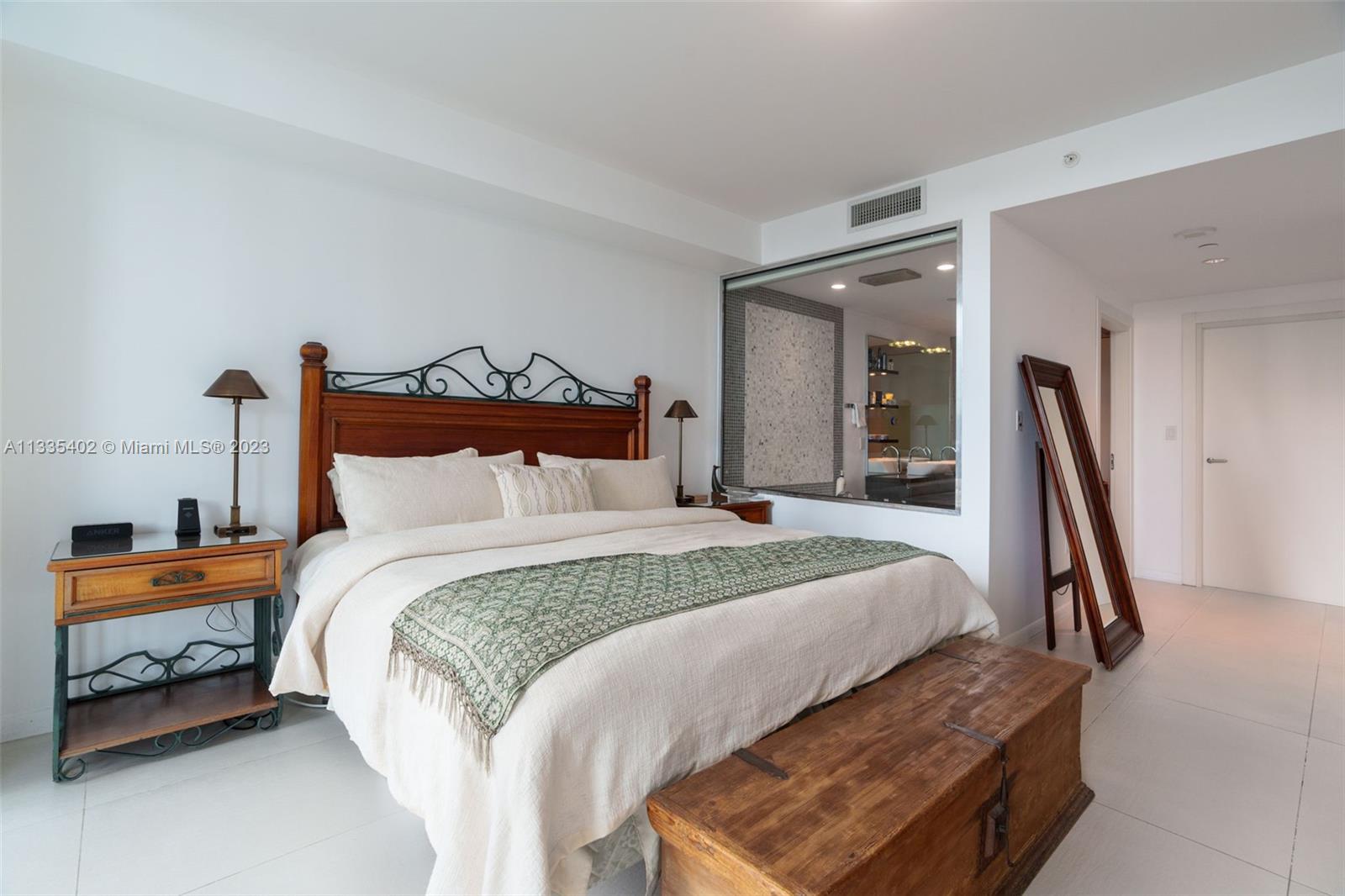 200 Biscayne Blvd Way, Unit 1404 Miami, FL 33131 - Photo 12 of 32 a bedroom with a bed and a large mirror