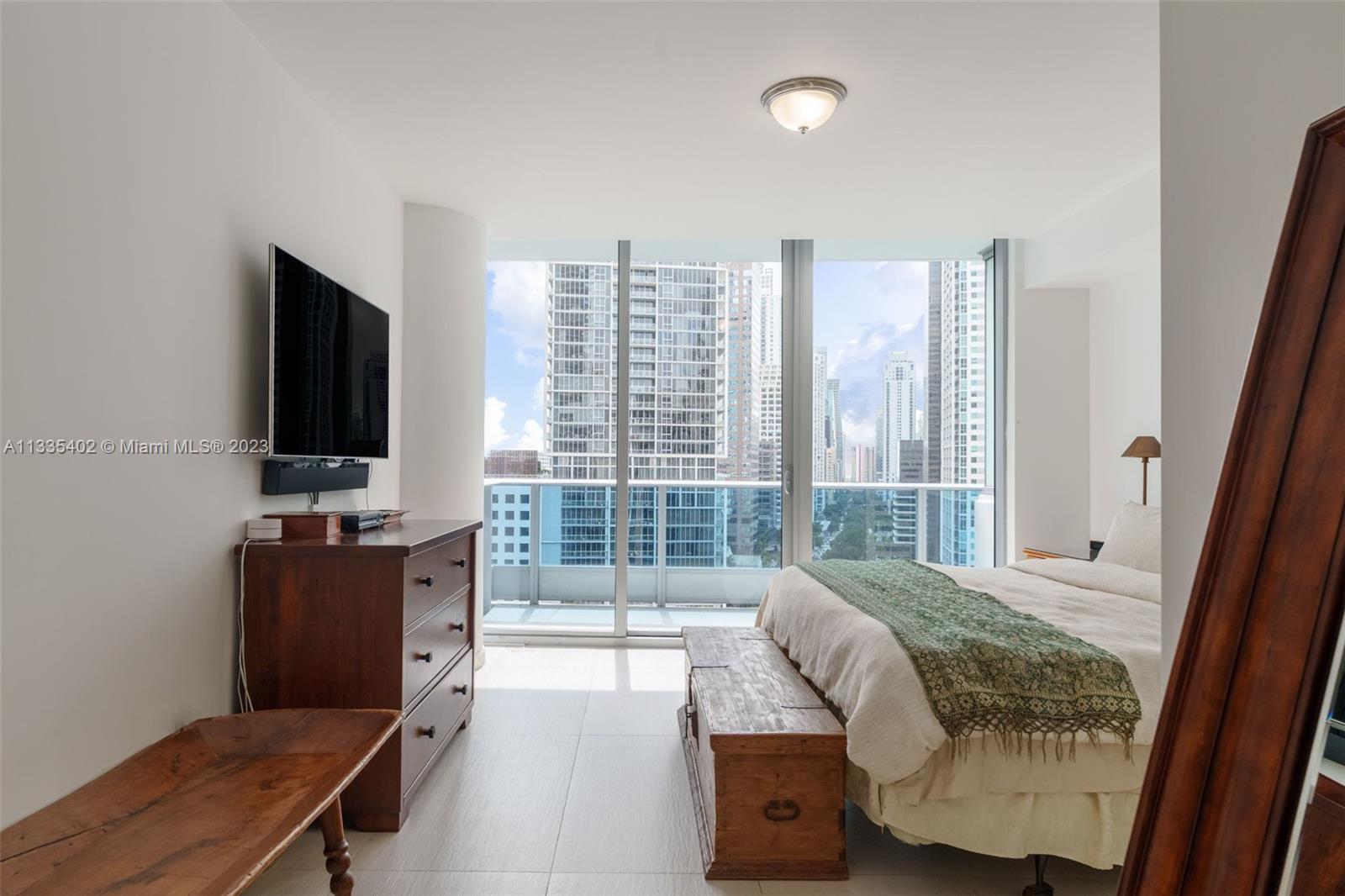 200 Biscayne Blvd Way, Unit 1404 Miami, FL 33131 - Photo 13 of 32 a bedroom with furniture and flat screen tv