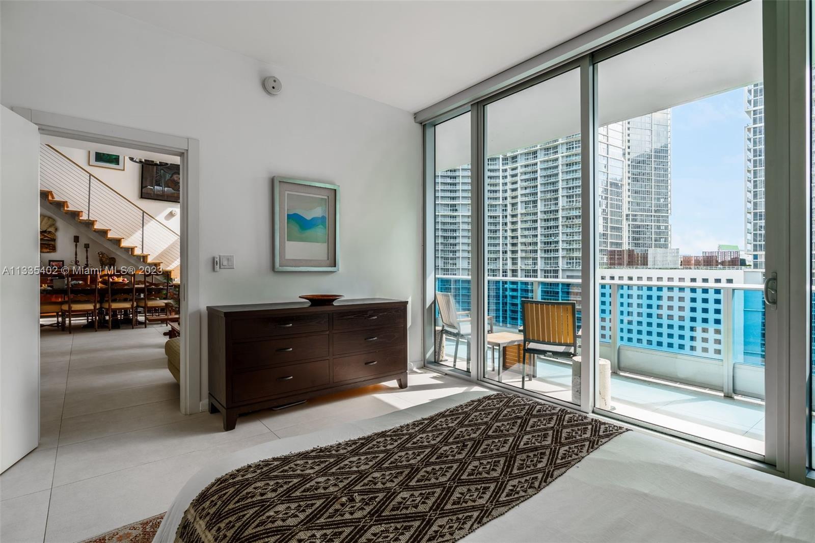 200 Biscayne Blvd Way, Unit 1404 Miami, FL 33131 - Photo 20 of 32 a bedroom with a bed and a lamp next to a window