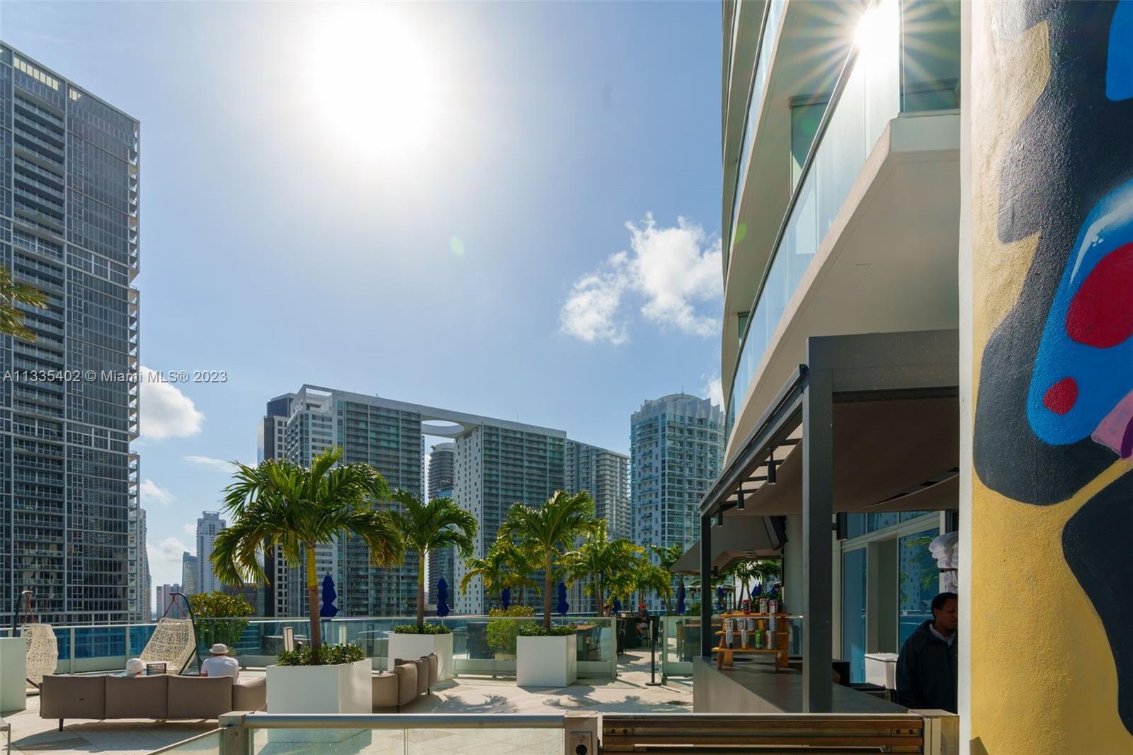 200 Biscayne Blvd Way, Unit 1404 Miami, FL 33131 - Photo 28 of 32 a front view of multi story residential apartment building with yard and sign board
