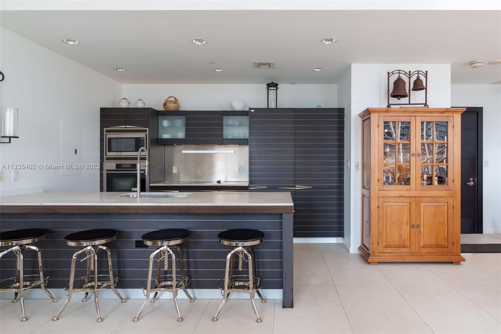 200 Biscayne Blvd Way, Unit 1404 Miami, FL 33131 - Photo 8 of 32 a kitchen with stainless steel appliances kitchen island granite countertop a refrigerator and microwave