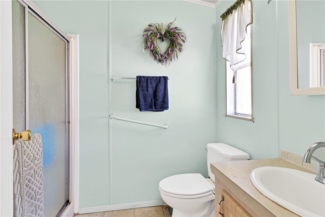 7571 Boxelder Road Micco, FL 32976 - Photo 17 of 36 a bathroom with a toilet sink and mirror