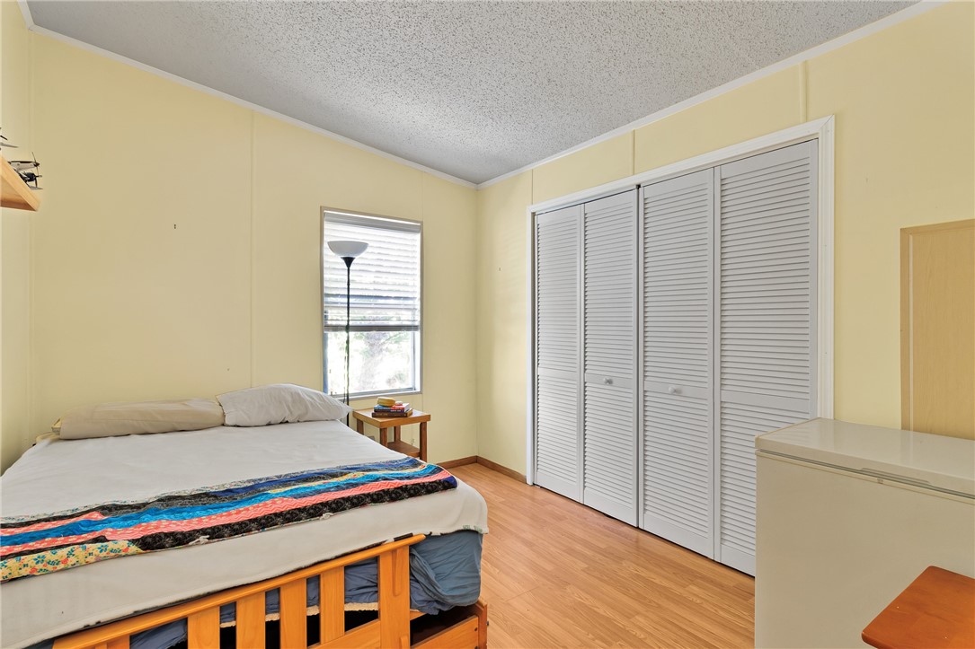 7571 Boxelder Road Micco, FL 32976 - Photo 18 of 36 a bedroom with a bed and wooden floor