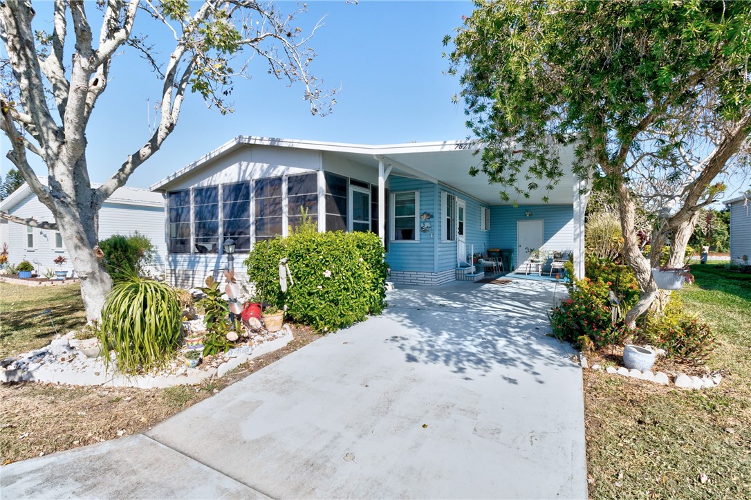 7571 Boxelder Road Micco, FL 32976 - Photo 2 of 36 a front view of a house with garden