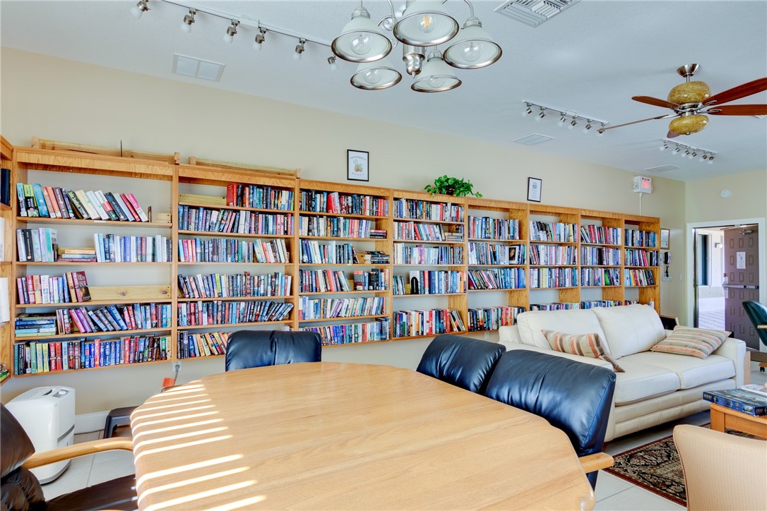 7571 Boxelder Road Micco, FL 32976 - Photo 35 of 36 a living room with a book shelf and a book shelf