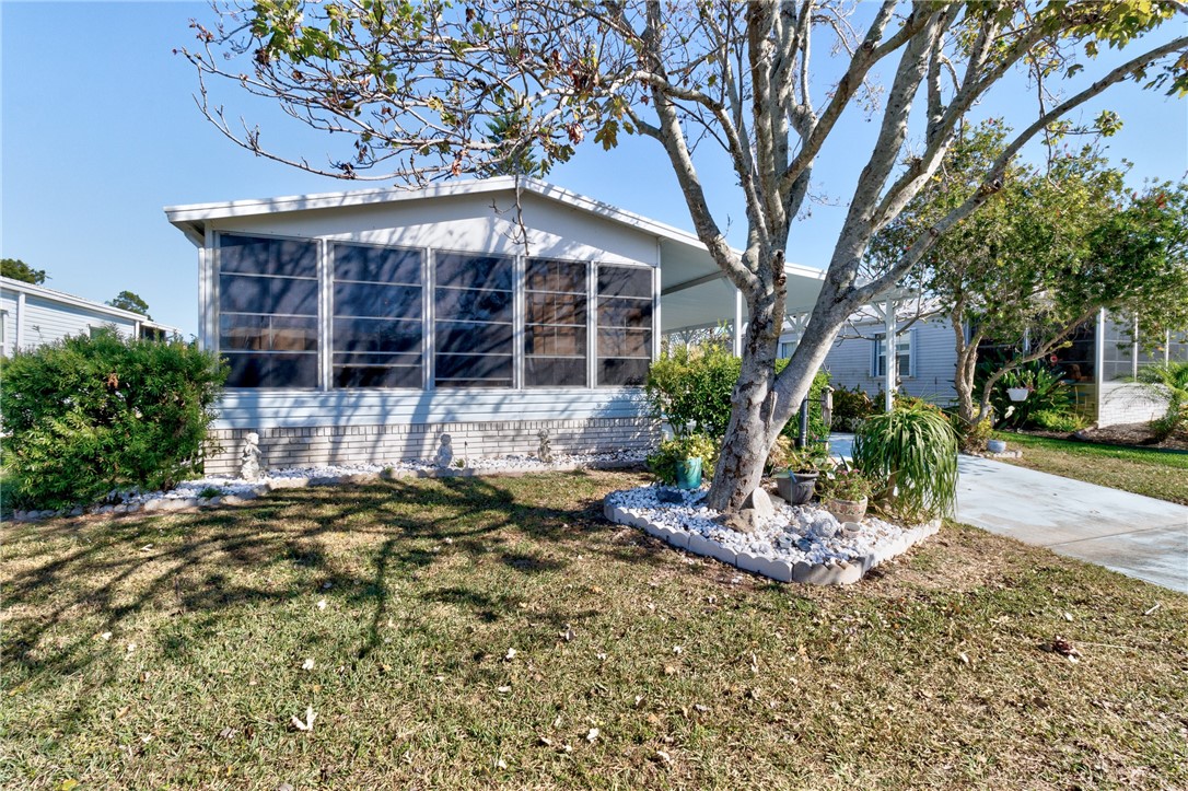 7571 Boxelder Road Micco, FL 32976 - Photo 4 of 36 a front view of a house with garden