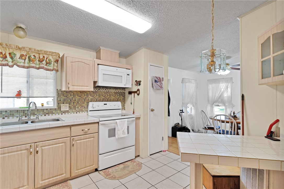 7571 Boxelder Road Micco, FL 32976 - Photo 10 of 36 a kitchen with white cabinets and sink