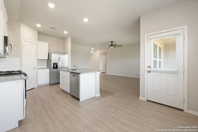 a kitchen with white cabinets and white appliances
